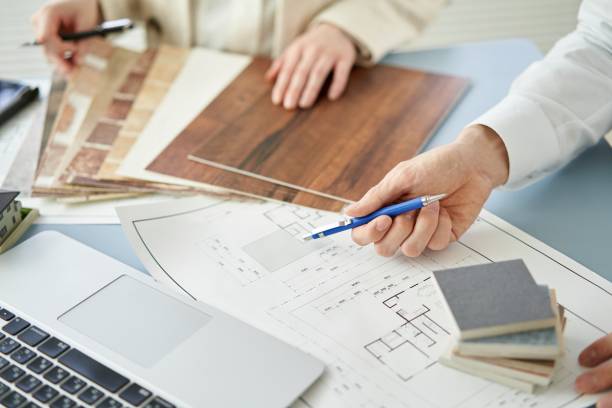 Was Innenarchitektur von einfacher Dekoration unterscheidet 3 Innenarchitekt präsentiert einem Kunden in einem hellen Büro Materialmuster und Pläne